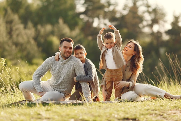 Family posing in grassy field.